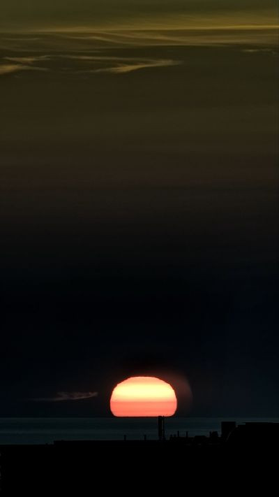 The distorted Sun sets below the horizon. - Astrophotography
